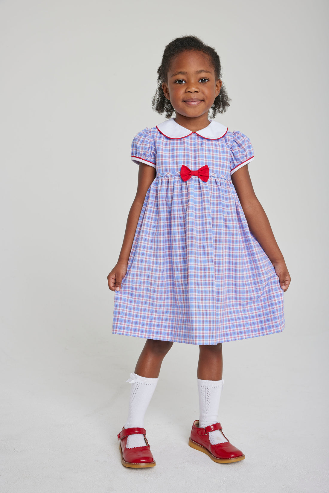 Little English toddler girl traditional red white and blue gingham woven dress with red and white piping
