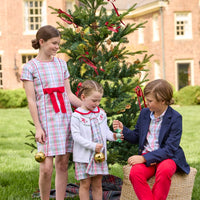Little English classic children's clothing. Girls A-line Cora Dress in red and green plaid with red bow and red piping detail for the holidays.  Boys Douglas Plaid button down shirt with red corduroy pants and navy wool blazer. Toddler girls Eleanor Dress - Douglas Plaid with ruffled peter pan collar and tie sash in back paired with white Holiday Bow Fair Isle Cardigan