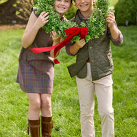 Little English traditional children's clothing. Olive and maroon Thornhill Plaid column dress with capped sleeves, ruffled neckline, and fixed bow in back for older girls for the holidays.  Boys Button Down Shirt in Thornhill Plaid with Classic Quilted Vest in Olive layered over top. Paired with Classic Pant in tan Stone Corduroy.