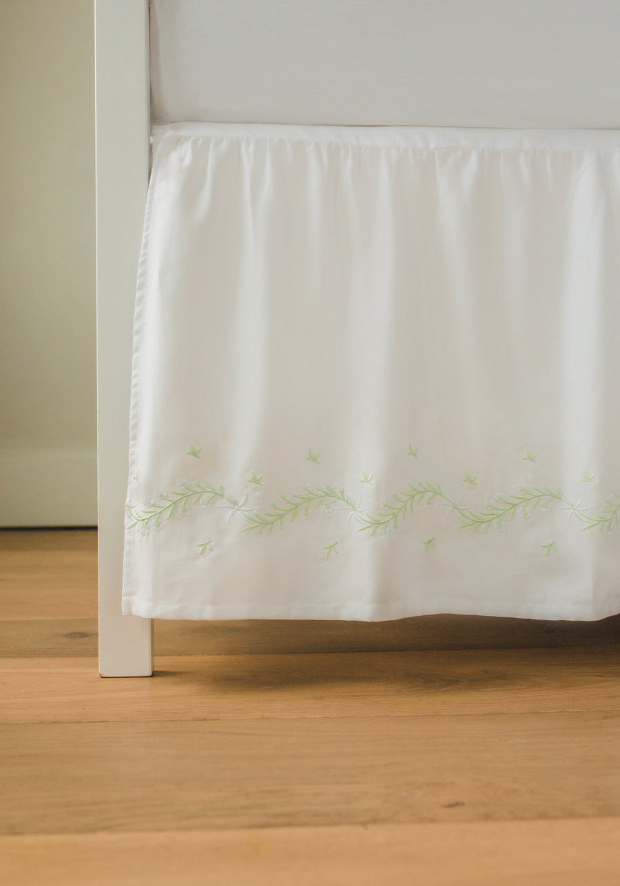 Little English classic nursery goods for baby, white crib skirt with simple light green embroidery along the edges for baby