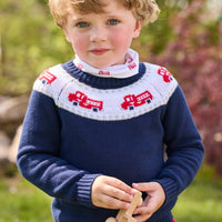 Little English traditional children's clothing. Navy crew neck sweater with red fire truck fair isle detail. Layered over white knit turtleneck with all-over fire truck print. Paired with red corduroy banded pants.  Fall outfit for toddler boys.