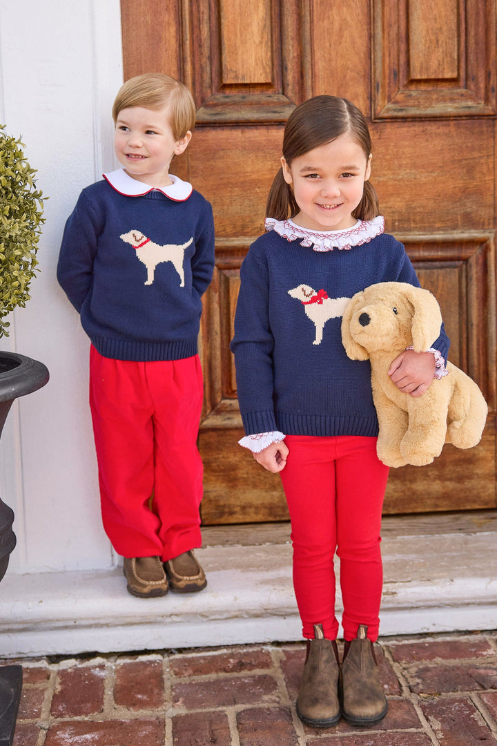 little english classic children's clothing boys navy sweater with cream lab motif, red piped peter pan shirt, and red banded corduroy pant. girls navy sweater with red bow on cream lab motif, smocked madeline blouse in red, and red leggings for fall 