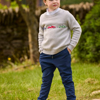 Little English traditional children's clothing.  Grey intarsia sweater with 3 race cars layered over race car print turtleneck and paired with tapered navy sport pants for little boys.