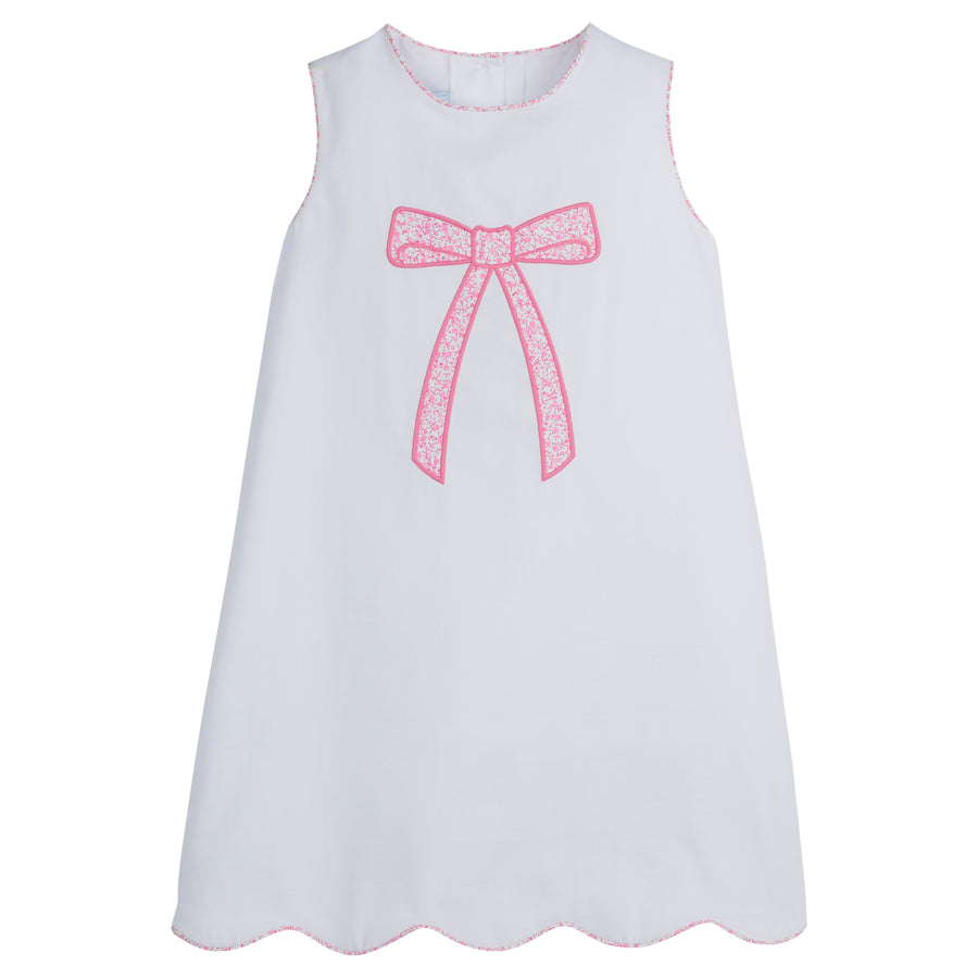 Little English traditional children’s clothing, classic girl's white dress for Spring with piping detail, bow motif in pink vinings print, and scallop hem