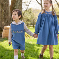 Little English traditional children's clothing.  Khaki Gingham peter pan shirt for toddler boys paired with stormy blue corduroy shortall with flying mallard smocking across chest. Long sleeve stormy blue corduroy dress with flying mallard collar around the neckline for little girls.