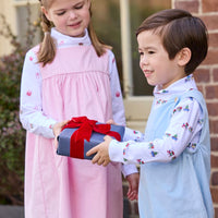 Little English classic children's clothing. White knit turtleneck with holiday train print layered under light blue corduroy Campbell Overall. White knit turtleneck with holiday present print layered under light pink corduroy Madison Jumper. Holiday outfit for little boys and girls.