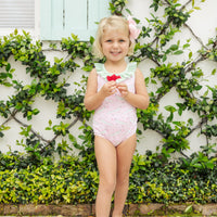 Little English traditional children's clothing. Pink swimsuit with green striped ruffled top and alligator pattern for little girls