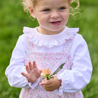 Little English traditional children's clothing.  Light pink and green floral overall with ruffle detailing layered over white knit smocked Madeline Blouse in light pink