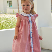 Little English, toddler girl's red seersucker gingham dress for Summer. Ruffle detailing on sleeve and down the center with a peter pan collar and blue embroidered stars down the placket. 4th of July outfit.