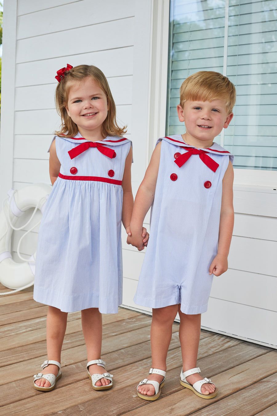 Little English traditional children's clothing, girl's classic thin light blue stripe dress with sailor collar, fixed neck tie, and red button detail for Summer