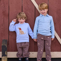 Little English traditional children's clothing.  Classic long sleeve light blue polo and chocolate brown corduroy pants with seated lab embroidery for boys.  Light blue crew neck intarsia sweater with seated lab motif layered over lab printed turtleneck and paired with chocolate brown corduroy banded pants.