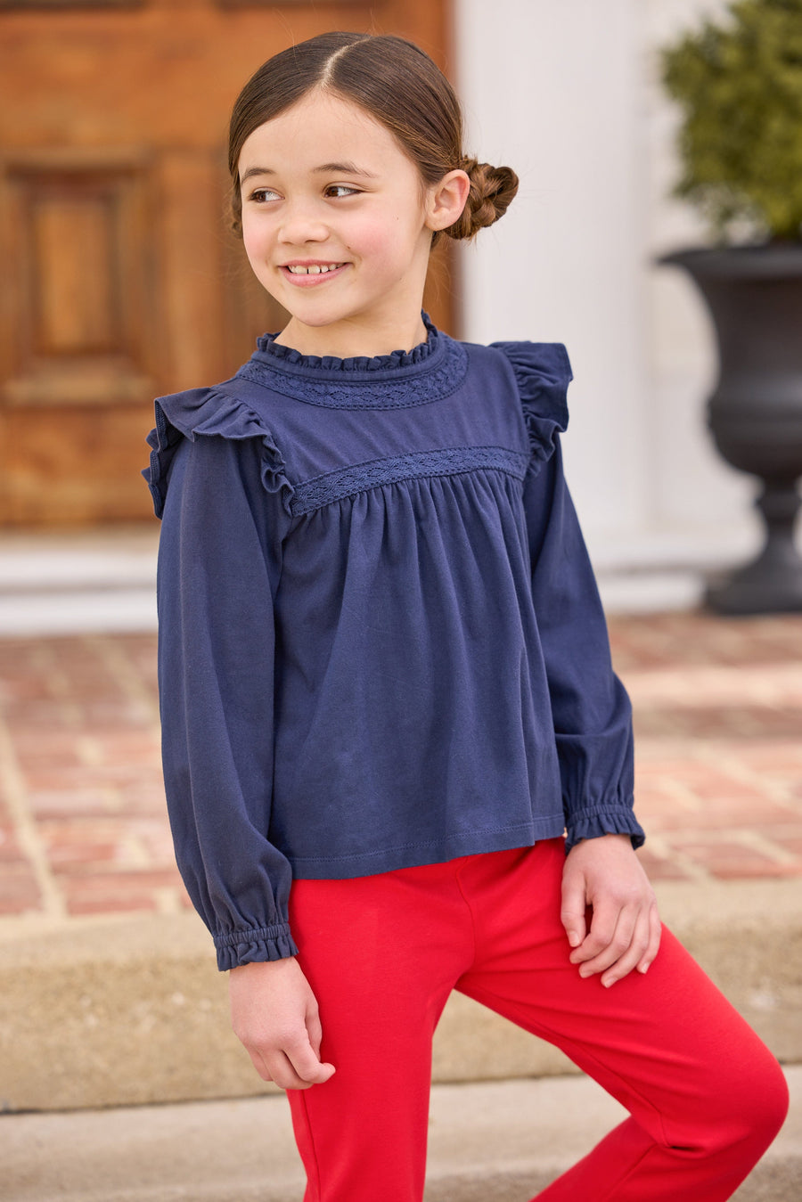 little english classic children's clothing girls navy long sleeve ruffle top with lace detailing a neck and chest, kick flare leggings in red, fall outfit for girl 