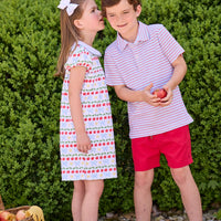 Little English classic children's clothing.  Short sleeve white knit peter pan dress with school themed print.  Boys red and blue Primary Stripe short sleeve polo paired with red Sport Short. Back to school outfit for girls and boys.