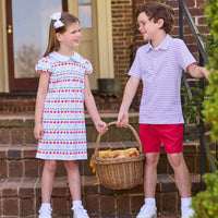 Little English classic children's clothing.  Short sleeve white knit peter pan dress with school themed print.  Boys red and blue Primary Stripe short sleeve polo paired with red Sport Short. Back to school outfit for girls and boys.