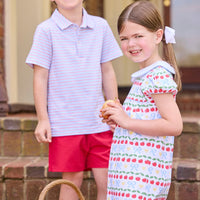 Little English classic children's clothing.  Short sleeve white knit peter pan dress with school themed print.  Boys red and blue Primary Stripe short sleeve polo paired with red Sport Short. Back to school outfit for girls and boys.