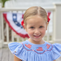 Little English traditional children's clothing. Flutter sleeve dress for toddler girls in royal blue mini gingham with smocking at the collar and American flag bunting