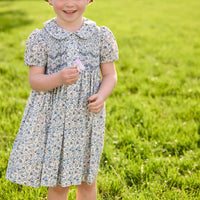 Little English traditional children's clothing. Capped sleeve blue, brown, and cream floral smocked dress with peter pan collar for little girls.