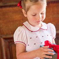 little english classic children's clothing white peter pan collar dress with cap sleeves and smocked detailing with red piping and holly embroidery for girls holiday 