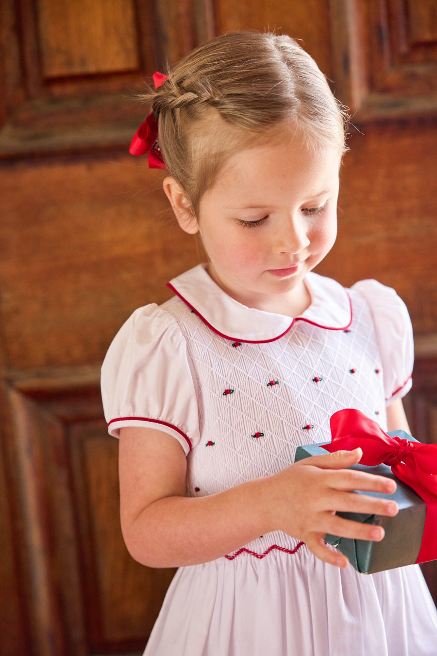 little english classic children's clothing white peter pan collar dress with cap sleeves and smocked detailing with red piping and holly embroidery for girls holiday 