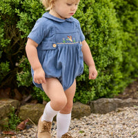 Little English classic children's clothing.  Baby boys stormy blue corduroy peter pan bubble with button tabs and flying mallard smocking across the chest.