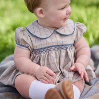 Little English classic children's clothing.  Smocked peter pan bubble in tan and blue Durham windowpane with puff sleeves and blue piping for baby girls