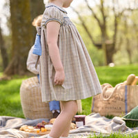 Little English traditional children's clothing.  Smocked peter pan dress in tan and blue Durham Windowpane with capped sleeves for toddler girls