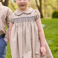 Little English traditional children's clothing.  Smocked peter pan dress in tan and blue Durham Windowpane with capped sleeves for toddler girls