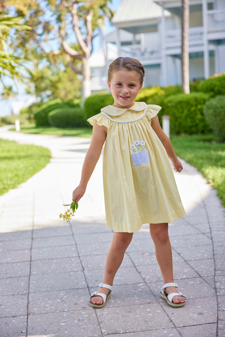 classic childrens clothing yellow dress with peter pan collar and front pocket with daisy embroidery