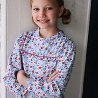 classic childrens clothing girls blouse in blue and red floral pattern with ruffles around neck and sleeves and red piping detailing